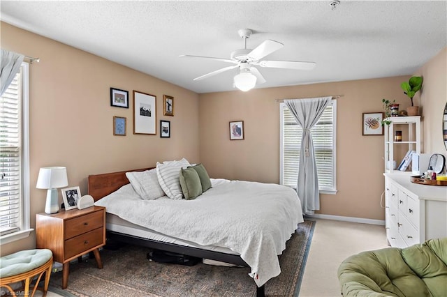 bedroom with ceiling fan, light colored carpet, and baseboards