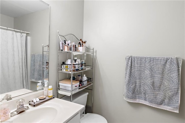 full bathroom featuring toilet, curtained shower, and vanity