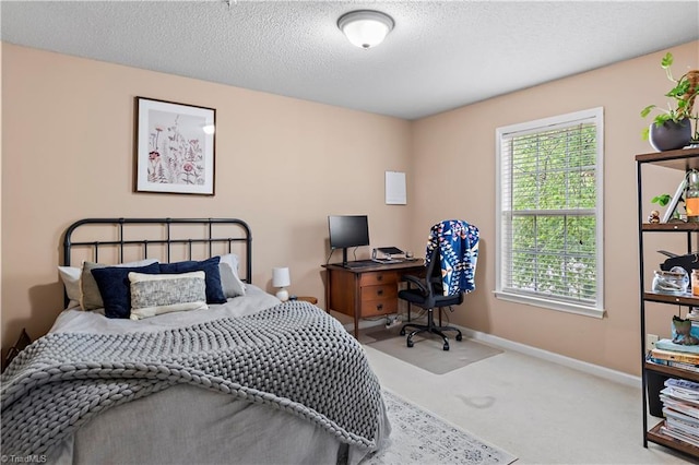 bedroom with baseboards, carpet, and a textured ceiling