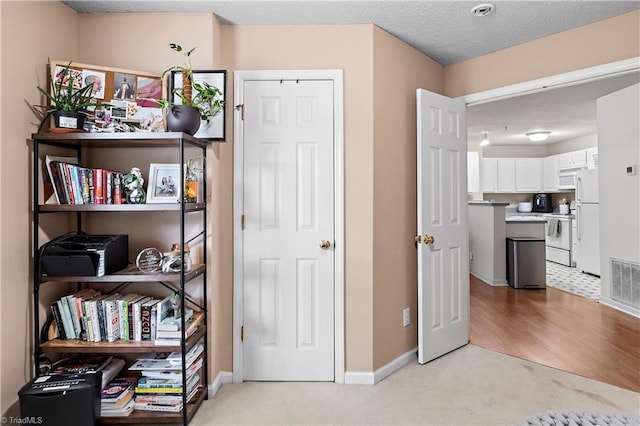 interior space with visible vents, baseboards, and light carpet