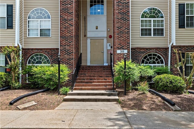 view of exterior entry featuring brick siding