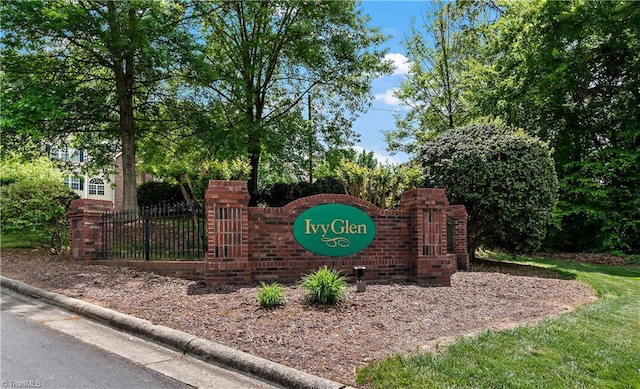 community / neighborhood sign featuring fence