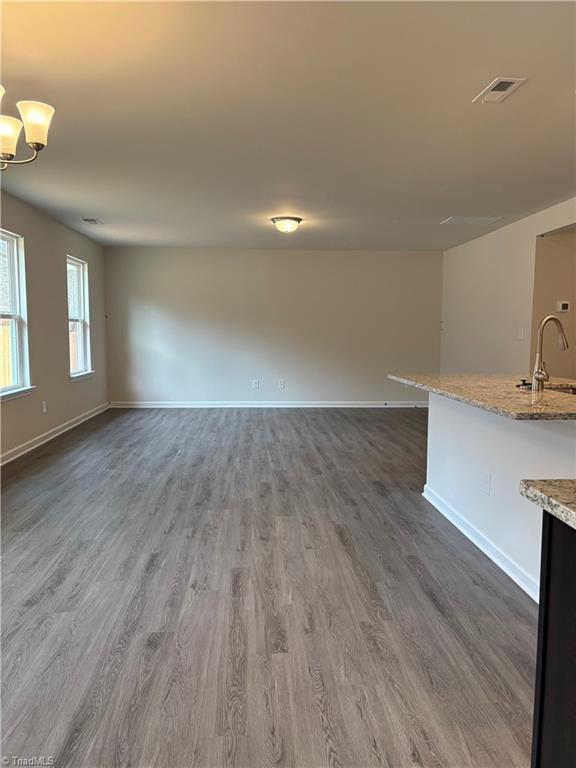 2892 Tysinger Rd, Denton, NC 27239 - unfurnished living room featuring baseboards, dark wood finished floors, a sink, and a chandelier