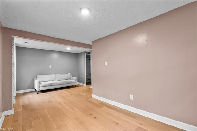 interior space featuring baseboards, a textured ceiling, light wood-style flooring, and recessed lighting