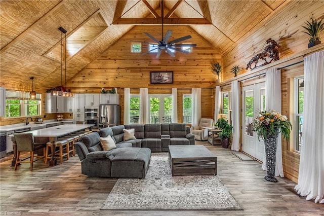 living room featuring wooden ceiling, wooden walls, high vaulted ceiling, wood finished floors, and french doors