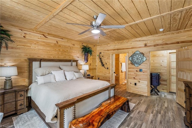 bedroom featuring wooden ceiling, wooden walls, wood finished floors, and a ceiling fan