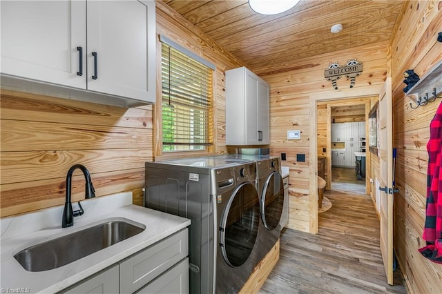 laundry area with cabinet space, washer and dryer, wooden walls, wood finished floors, and wood ceiling