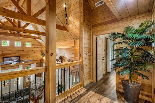 hall with wooden walls, wood ceiling, hardwood / wood-style flooring, beamed ceiling, and high vaulted ceiling