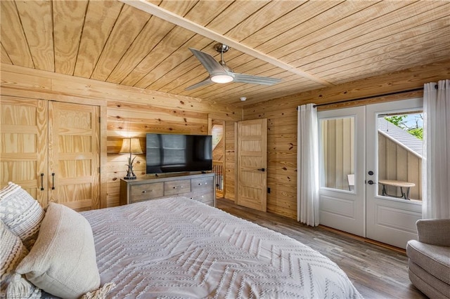 bedroom with wood ceiling, wood-type flooring, wood walls, french doors, and ceiling fan