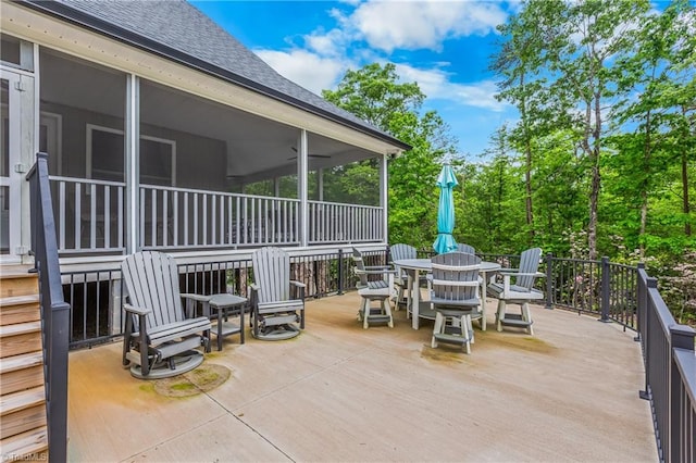 view of patio / terrace with a sunroom and outdoor dining space