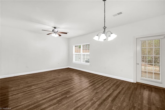 unfurnished room with visible vents, baseboards, dark wood-type flooring, and ceiling fan with notable chandelier