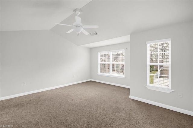 spare room with visible vents, baseboards, lofted ceiling, ceiling fan, and dark carpet