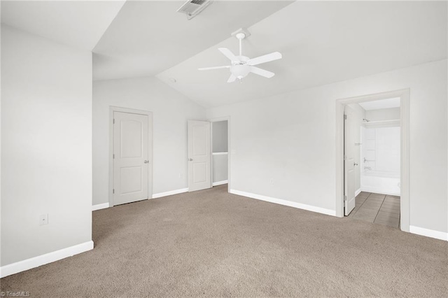 unfurnished room featuring visible vents, baseboards, carpet, and vaulted ceiling