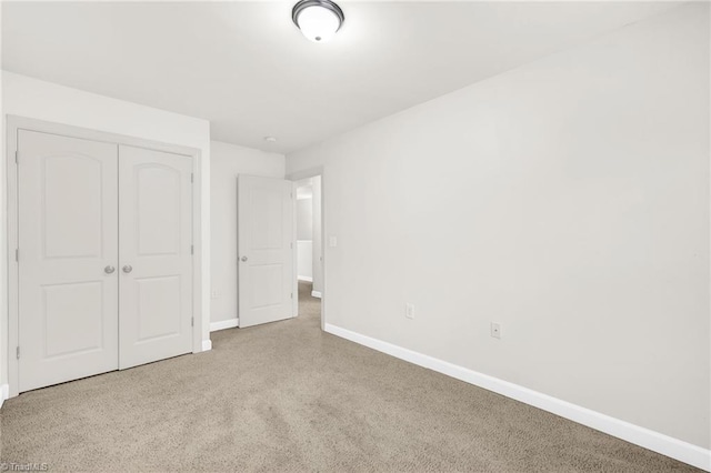 unfurnished bedroom featuring a closet, carpet flooring, and baseboards