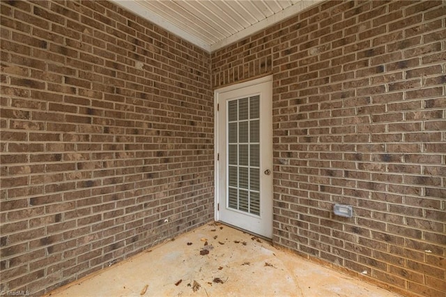 view of exterior entry featuring brick siding