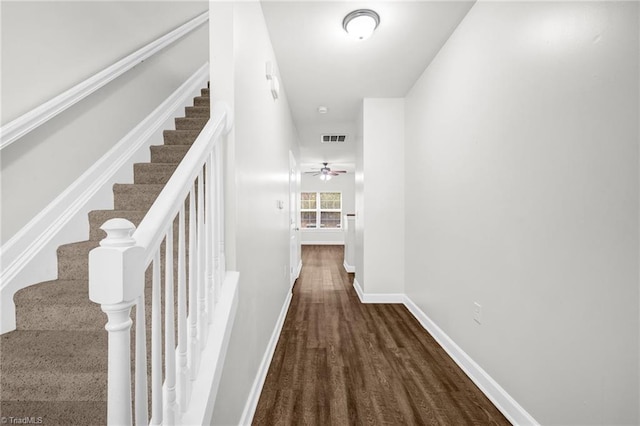 corridor with visible vents, baseboards, wood finished floors, and stairway