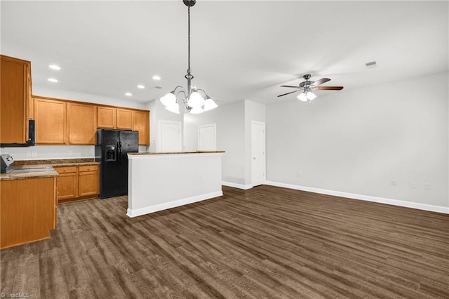 kitchen with black fridge, a center island, range, baseboards, and dark wood-style flooring