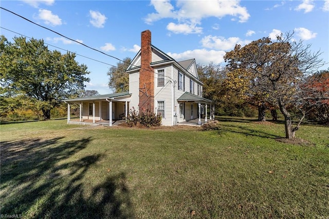 rear view of house featuring a yard and a porch