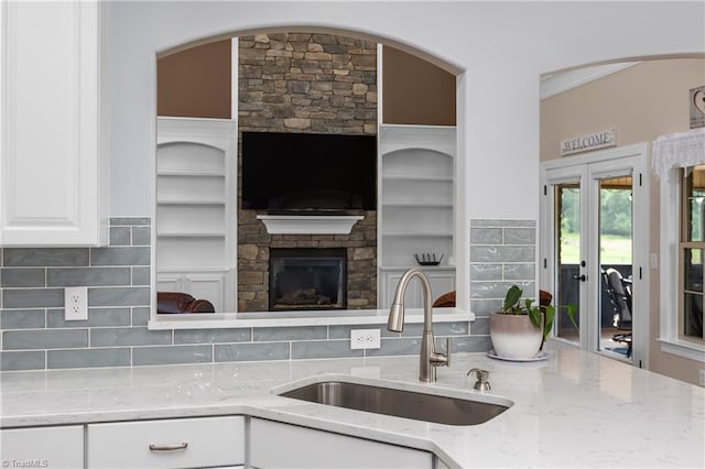 6147 Olde Fields Way, Pfafftown, NC 27040 - kitchen featuring light stone counters, a fireplace, white cabinetry, open floor plan, and backsplash