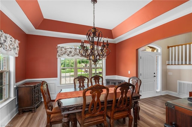 6147 Olde Fields Way, Pfafftown, NC 27040 - dining space with a chandelier, wood finished floors, a raised ceiling, wainscoting, and ornamental molding