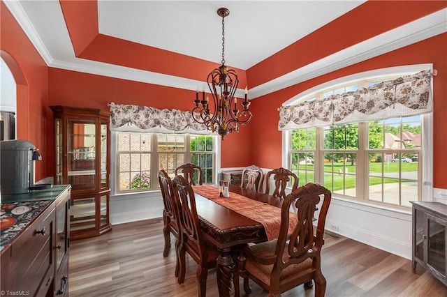 6147 Olde Fields Way, Pfafftown, NC 27040 - dining space featuring a chandelier, arched walkways, wood finished floors, plenty of natural light, and crown molding