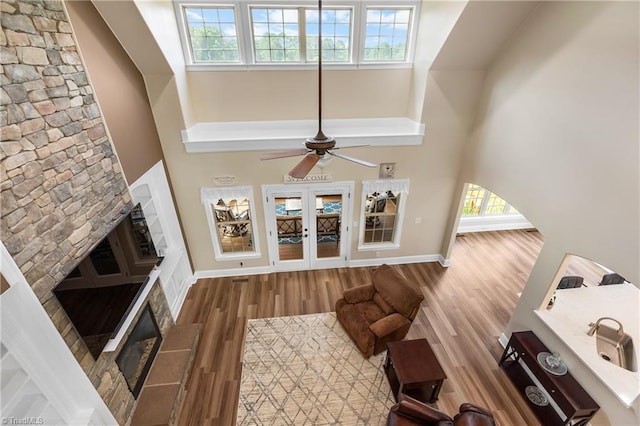 6147 Olde Fields Way, Pfafftown, NC 27040 - living room with a high ceiling, ceiling fan, wood finished floors, and a stone fireplace