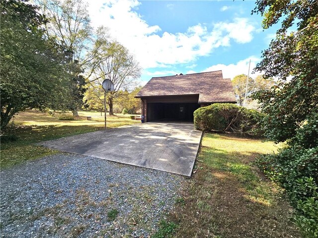 view of side of property featuring a garage and a lawn