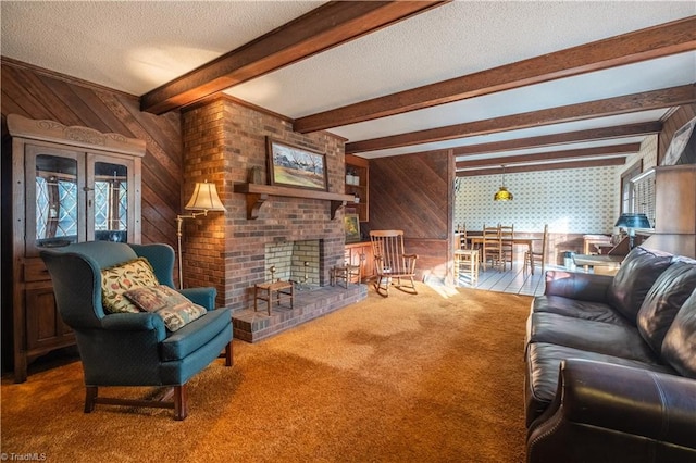 carpeted living room featuring wood walls, beamed ceiling, a textured ceiling, and a fireplace