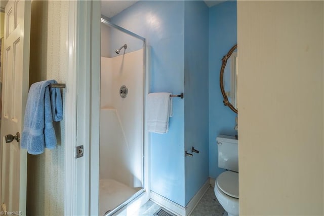 bathroom featuring walk in shower, tile patterned floors, and toilet