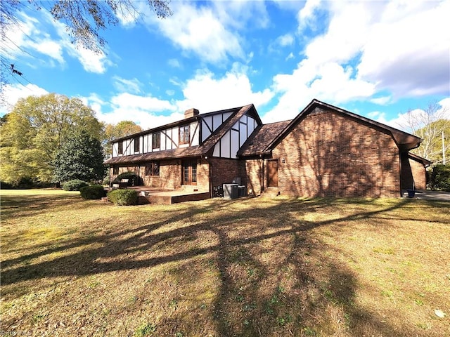 rear view of house featuring central AC unit and a yard