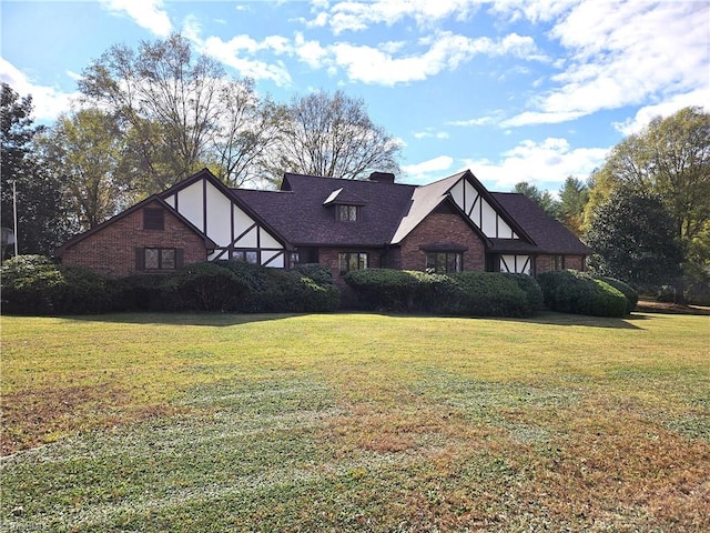 english style home featuring a front yard