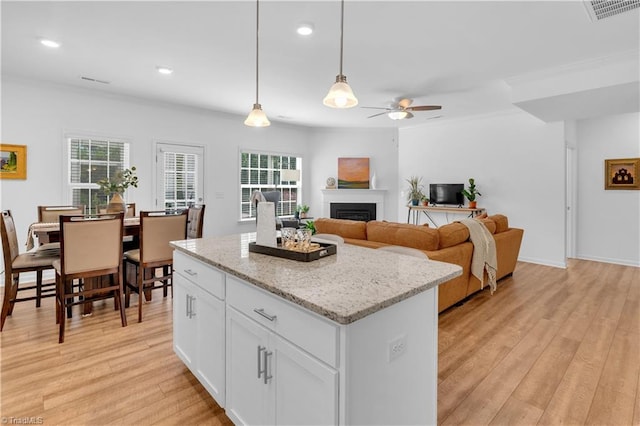 817 Sage Hill Dr, Jamestown, NC 27282 - kitchen with ceiling fan, light wood-style floors, a fireplace, a center island, and pendant lighting