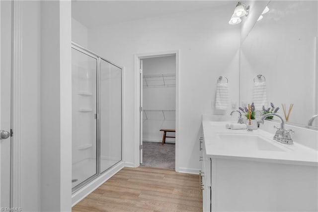 817 Sage Hill Dr, Jamestown, NC 27282 - bathroom featuring a shower stall, double vanity, wood finished floors, and a spacious closet