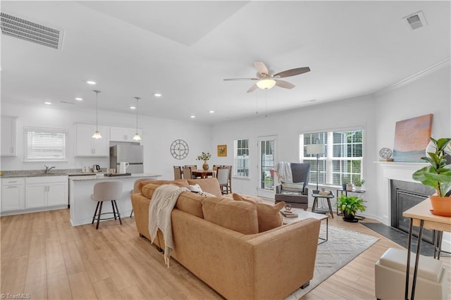 817 Sage Hill Dr, Jamestown, NC 27282 - living room with light wood finished floors, ceiling fan, recessed lighting, a high end fireplace, and crown molding