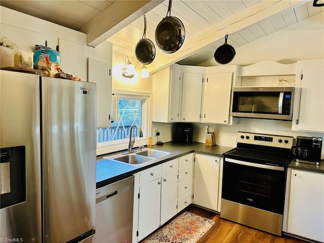 kitchen featuring appliances with stainless steel finishes, dark hardwood / wood-style floors, sink, white cabinets, and beamed ceiling