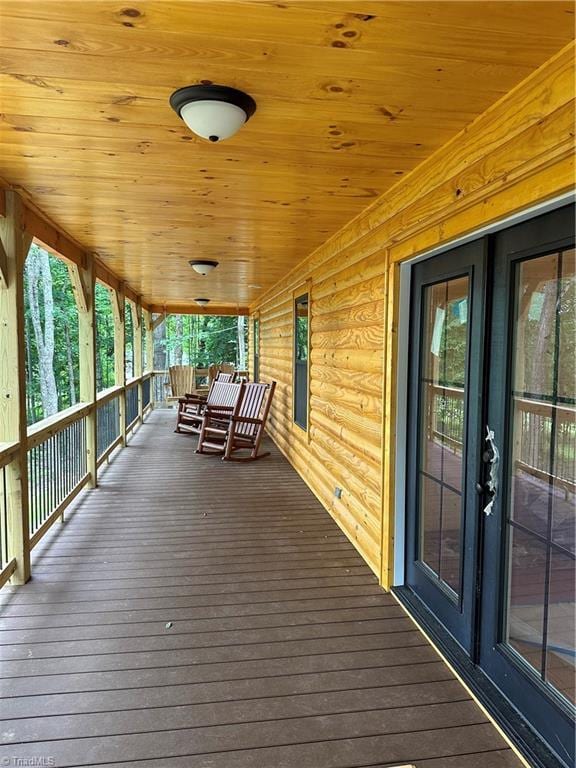 wooden deck featuring a porch and french doors