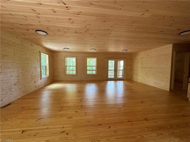 spare room featuring light hardwood / wood-style floors, wooden ceiling, brick wall, and french doors