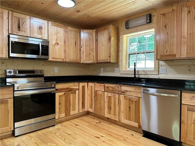 kitchen with stainless steel appliances, light hardwood / wood-style flooring, wood ceiling, and sink