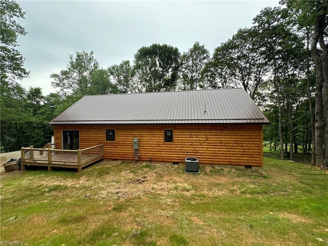 view of side of property featuring a lawn, a wooden deck, and cooling unit