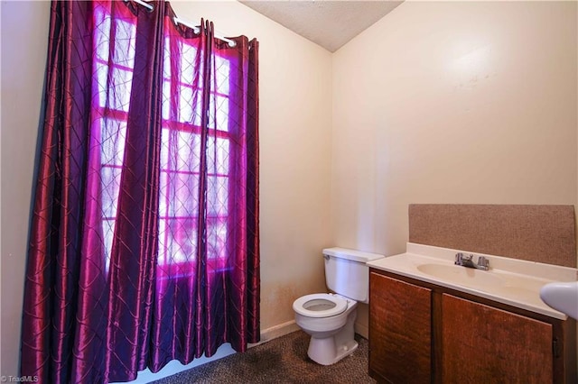 bathroom with vanity, toilet, and a textured ceiling