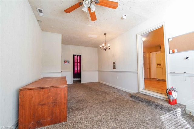 unfurnished room featuring ceiling fan with notable chandelier and carpet floors