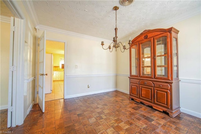 unfurnished dining area featuring dark parquet flooring, ornamental molding, a textured ceiling, and a chandelier