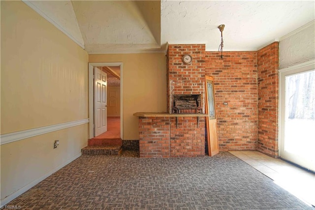 unfurnished living room with dark carpet and brick wall