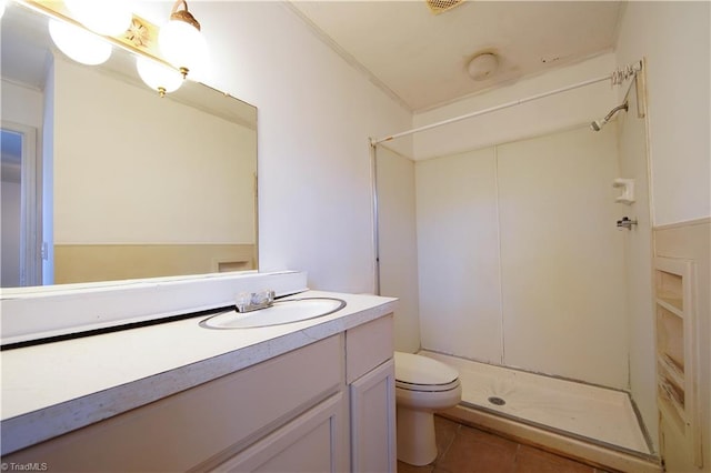 bathroom with vanity, crown molding, tile patterned flooring, toilet, and walk in shower