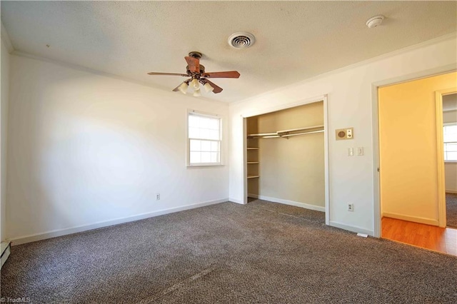 unfurnished bedroom with ceiling fan, dark carpet, ornamental molding, and a closet