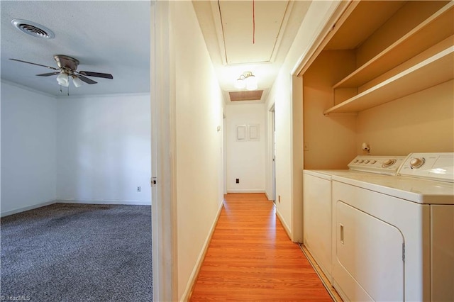 laundry room featuring washing machine and clothes dryer, ceiling fan, light hardwood / wood-style flooring, and crown molding