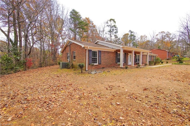 ranch-style house with a porch and central air condition unit