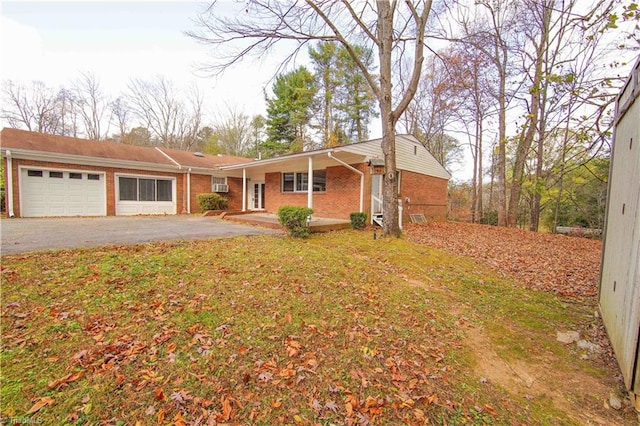 view of front of house featuring a garage, an AC wall unit, and a front lawn