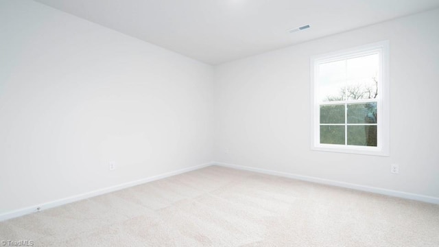 unfurnished room featuring visible vents, baseboards, and light carpet