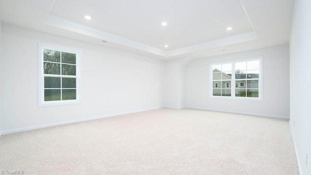 carpeted empty room featuring recessed lighting, baseboards, a raised ceiling, and ornamental molding